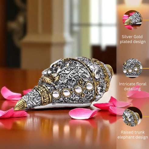 Decorative elephant figurine with intricate design on a wooden surface with pink petals.