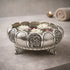 Decorative silver bowl with floral design on a gray surface