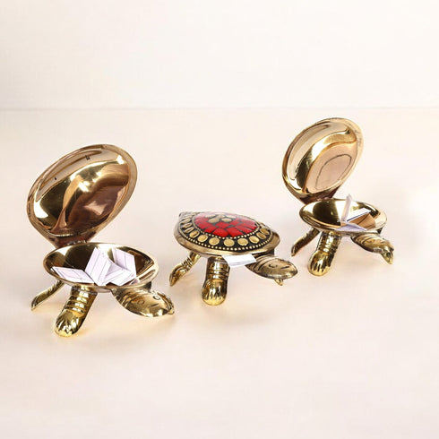 A set of three brass tortoise figurines with a secret compartment in the center turtle, displayed against a light background.