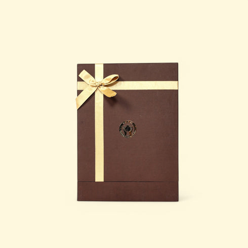 Brown gift box with a gold ribbon on a beige background