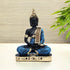 Decorative Buddha statue with blue and gold attire on a plain background