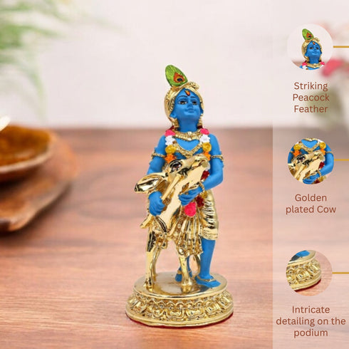 Decorative figurine of a blue-skinned deity on a gold cow with intricate detailing, placed on a wooden surface.
