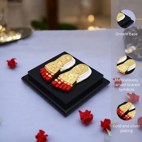 Decorative items with gold and silver plating on a black base, surrounded by red flowers.