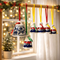 Decorative Christmas bells with colorful ribbons hanging on a wooden rod against a blurred festive background.