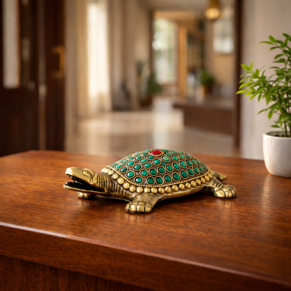 Decorative turtle figurine with green and gold details on a wooden surface