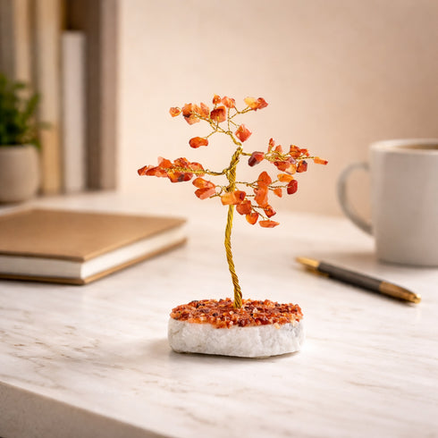 Decorative bonsai tree on a marble base with a cup, notebook, and pen in the background.