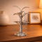 Decorative silver plant sculpture on a wooden surface with a blurred background