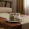 Two glass jars with silver lids on a decorative tray in a home setting.