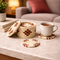 Woven coasters with a mug of tea on a marble surface in a cozy living room.