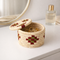 Woven jewelry box with a geometric pattern on a white surface