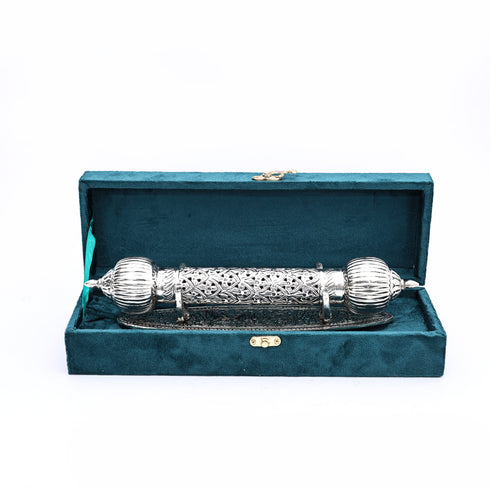 Decorative silver rod with intricate patterns in a teal box on a white background
