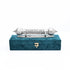 Decorative silver object on a teal box with a white background