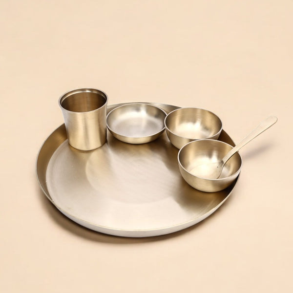 Set of metallic bowls and a cup on a beige background