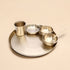 Set of metallic bowls and a cup on a beige background