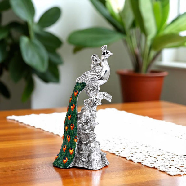 Silver-plated Peacock sitting on the branch