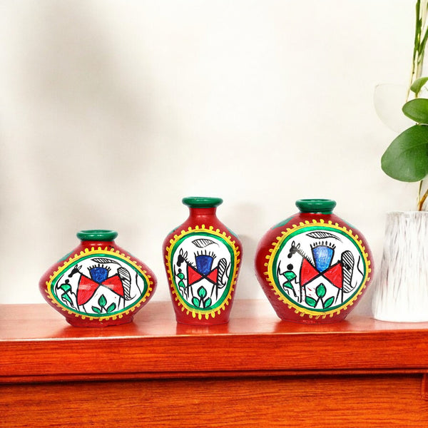 Three decorative vases with colorful patterns on a wooden surface.