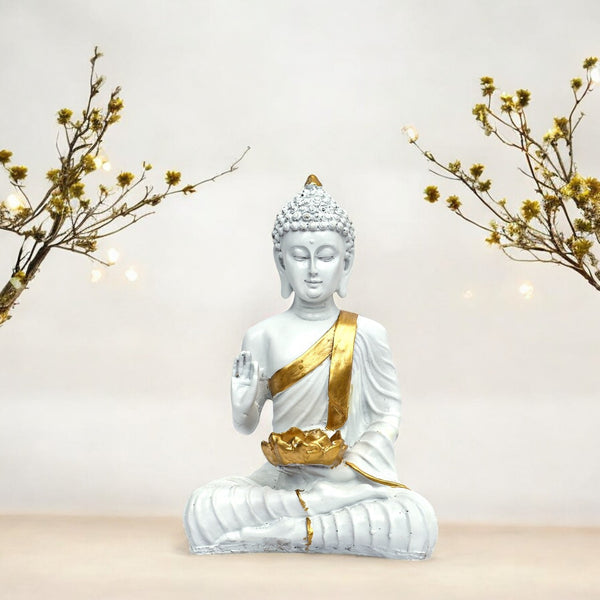 White Buddha statue with gold accents on a neutral background