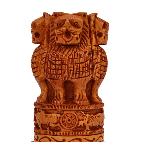 Close-up of carved lions and wheel detail on small wooden Ashoka Stambh