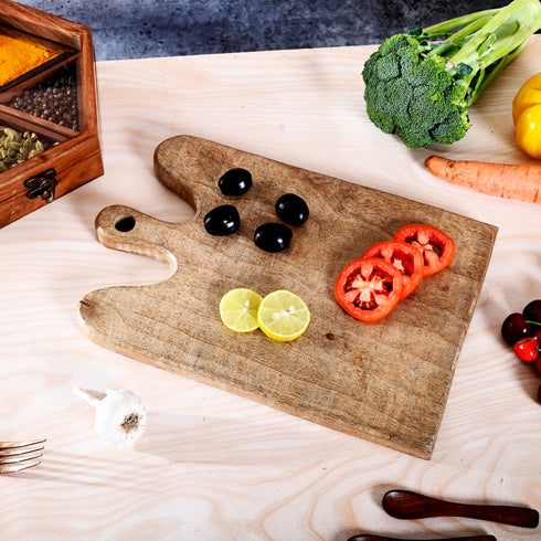 Wooden cutting board with sliced vegetables on a wooden table