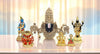 Set of decorative statues on a reflective surface with a blurred background