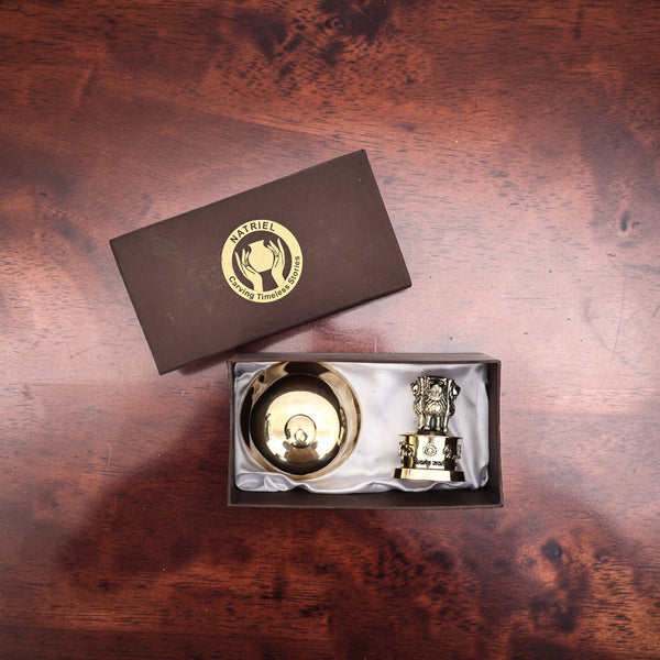Two gold items in a box with a brand logo on a wooden surface