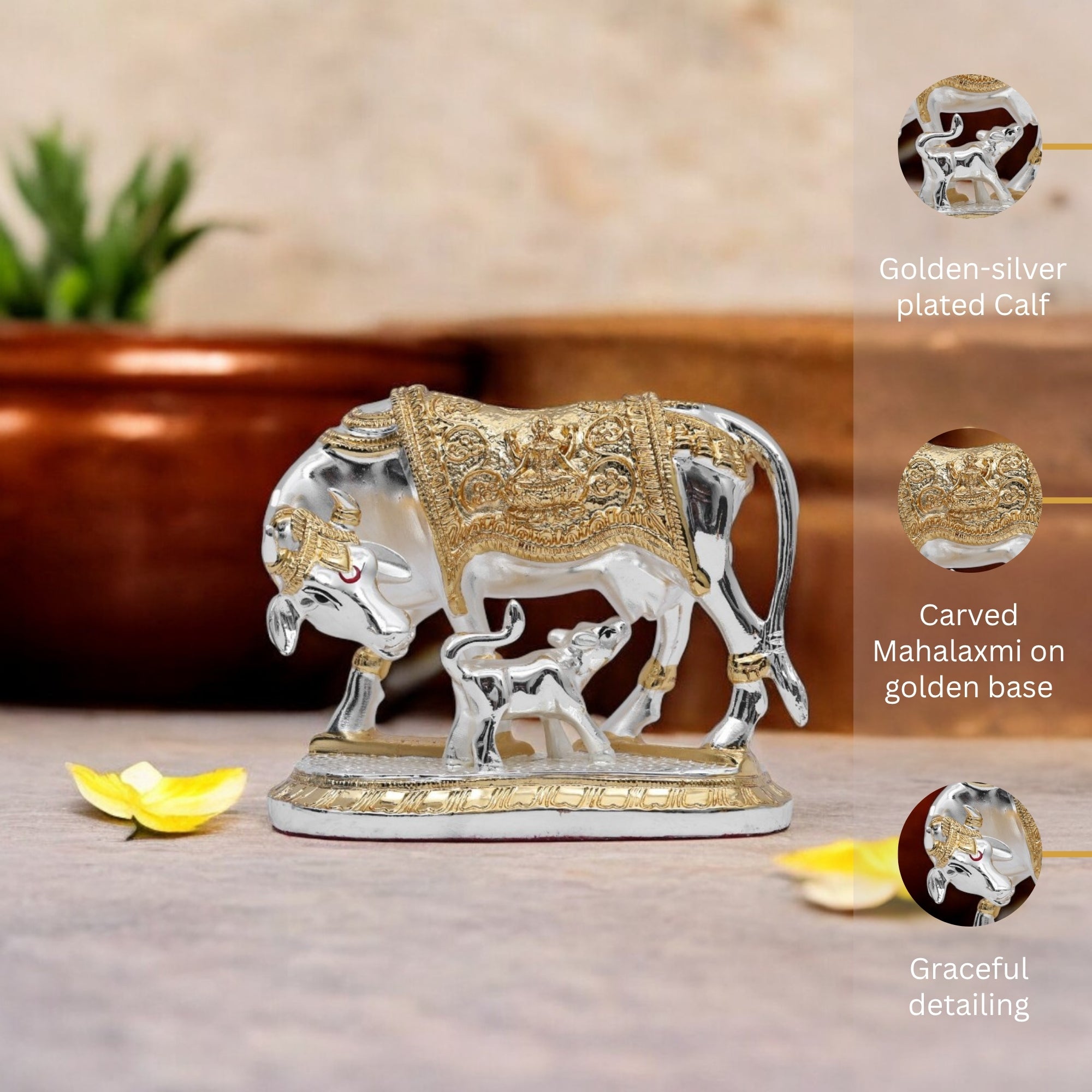 Decorative elephant statue with gold and silver finish on a wooden surface.