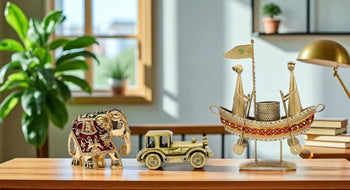Decorative items including a gold elephant, car, and decorative ship on a wooden surface with a plant and books in the background.