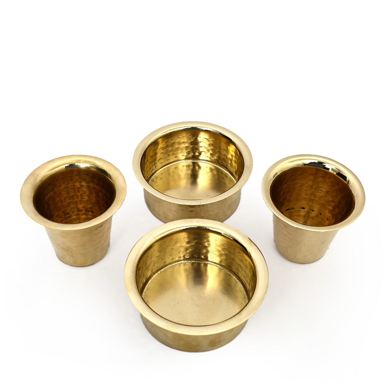 Four brass cups of varying sizes on a white background