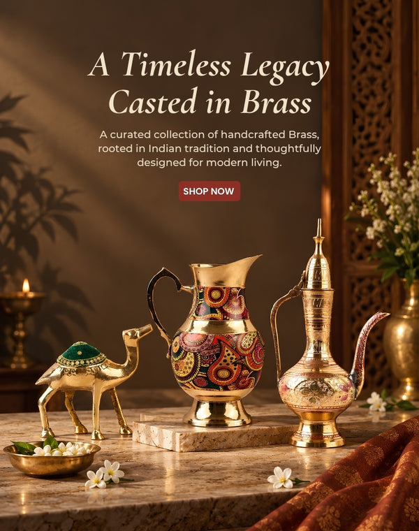 A styled product display of ornate brass vessels on a marble surface in a warm, decorative interior. The collection includes a tall patterned brass pitcher, a traditional brass dallah pot, a small camel figurine, and a bowl of flowers, with text at the top reading 'A Timeless Legacy Casted in Brass' and a 'SHOP NOW' button.
